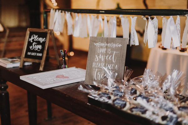 A Wedding Guest Book laid out on a table with signs on each side of it