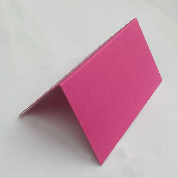 Made from an stylish fuchsia pink 350gsm card, these folded place cards are sold in packs of 20