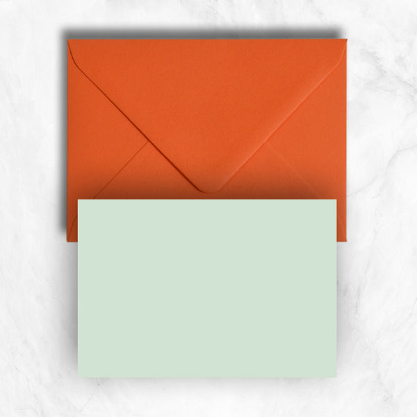 Plain lightly textured pastel powder green a6 cards teamed with orange envelopes