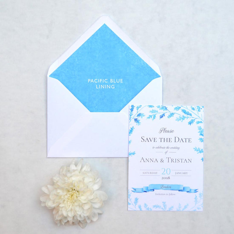 The Lillehammer save the date card printed in ice blue and black with Pacific blue tissue lined envelopes