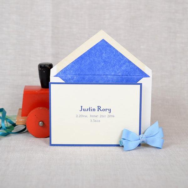 The folded Portnall birth announcement cards and envelope with blue tissue paper lining 