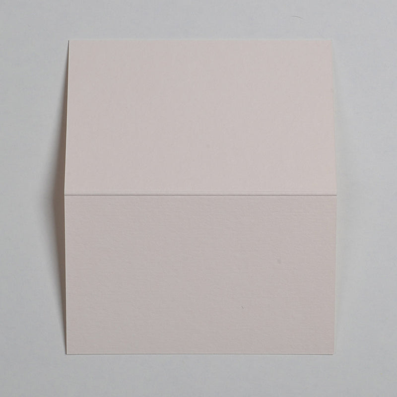 he Rose White Wedding name place cards shown flat on a table surface with the crease in the middle