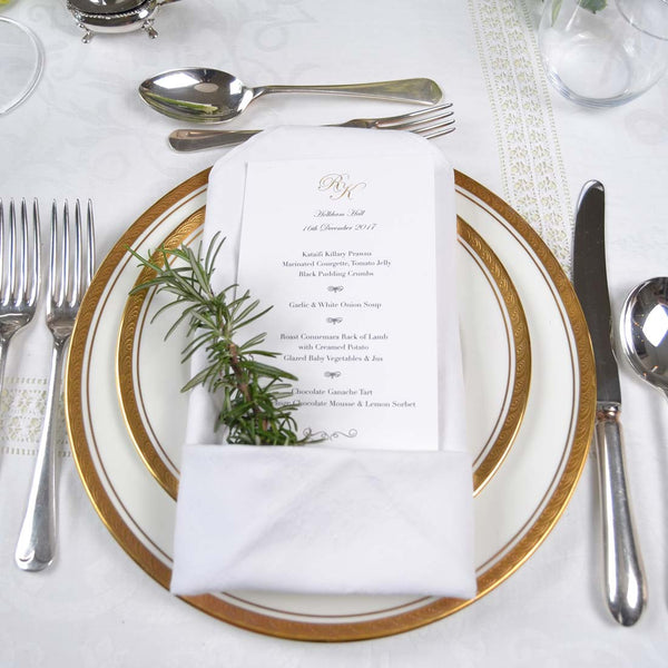 The Holkham wedding menu, uses a gold engraved monogram at the head and menu text raised printed below it in black on a white card