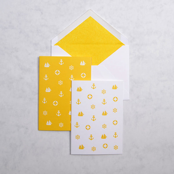 the yellow and white Marbella nautical greeting cards show 3 nautical motifs on portrait cards, with matching yellow tissue paper lined white envelopes