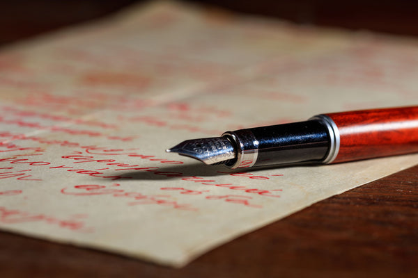 An fountain pen resting on a hand written letter 