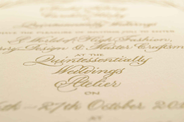 Gold engraved calligraphy on a cream card showing an example of wedding invitation wording