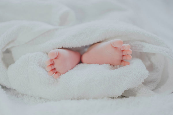 Baby feet sticking out of duvet