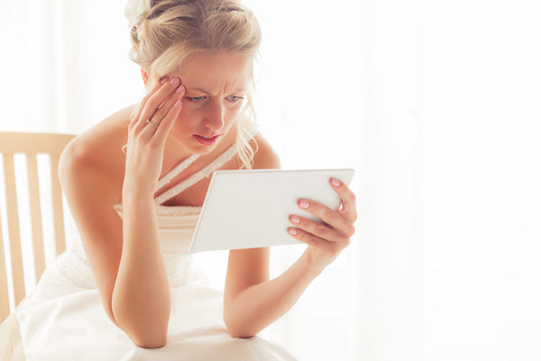 A bride looking exasparated at her wedding invitation