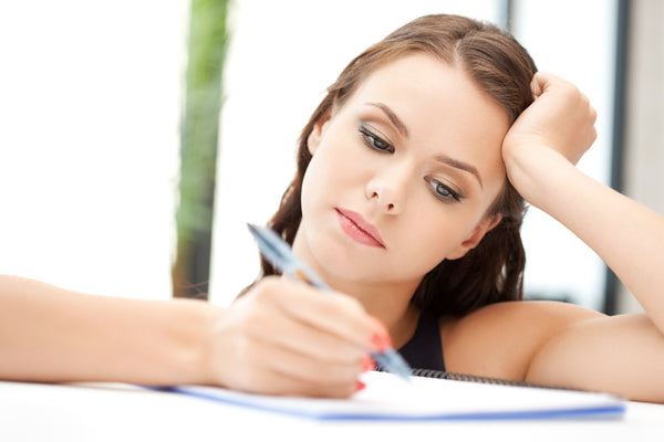 a woman sitting down to write a letter