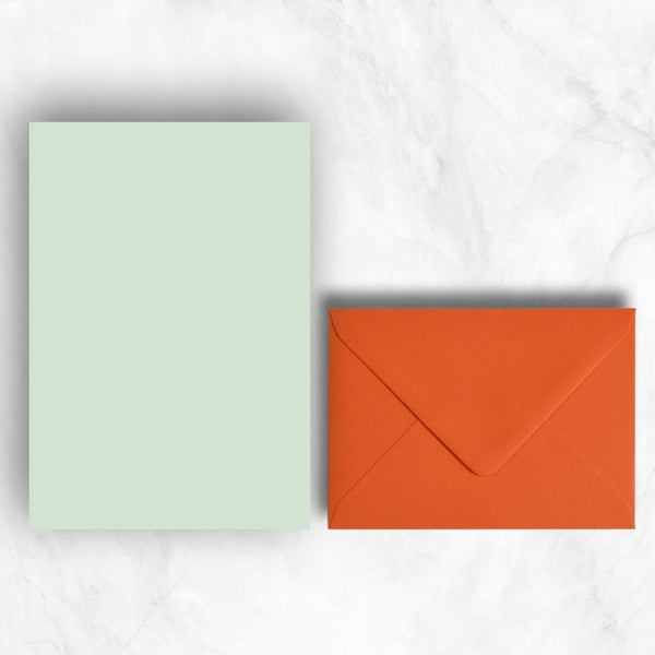 Plain lightly textured powder green a5 sheets teamed with orange envelopes