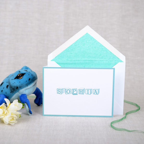 The folded Allendale birth announcement cards and envelope with teal tissue paper lining