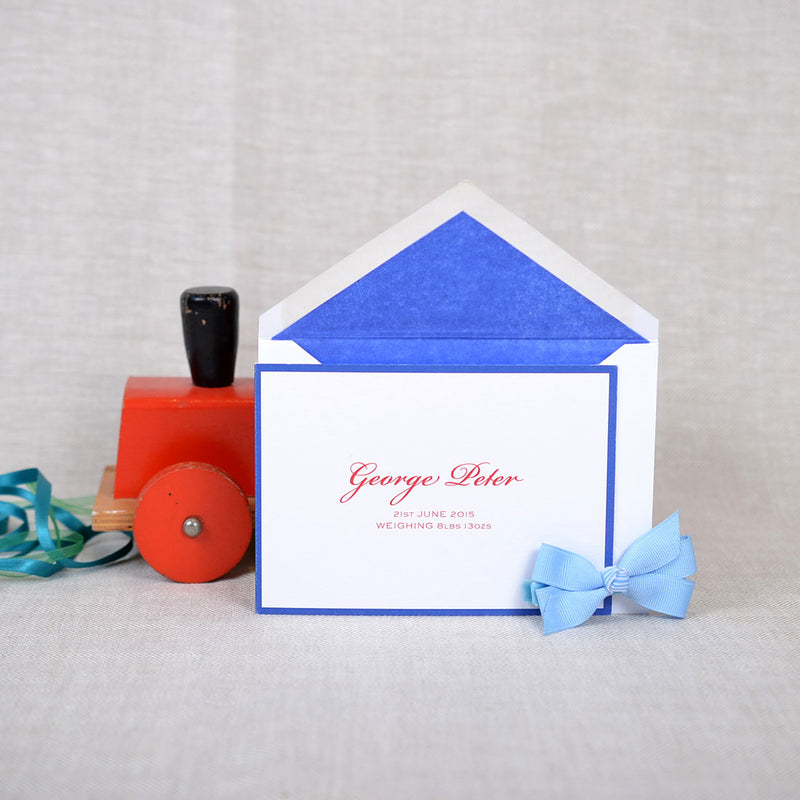 The folded Branson birth announcement cards and envelope with dark blue tissue paper lining 