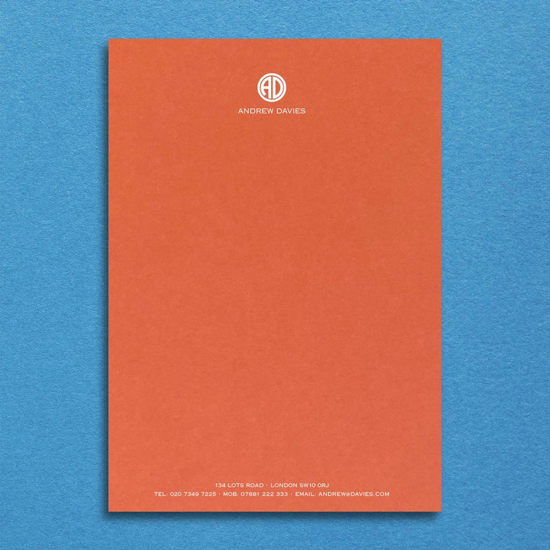 Bronte writing paper displays a contemporary monogram at the head and details at the foot, printed in white ink onto a mandarin orange sheet