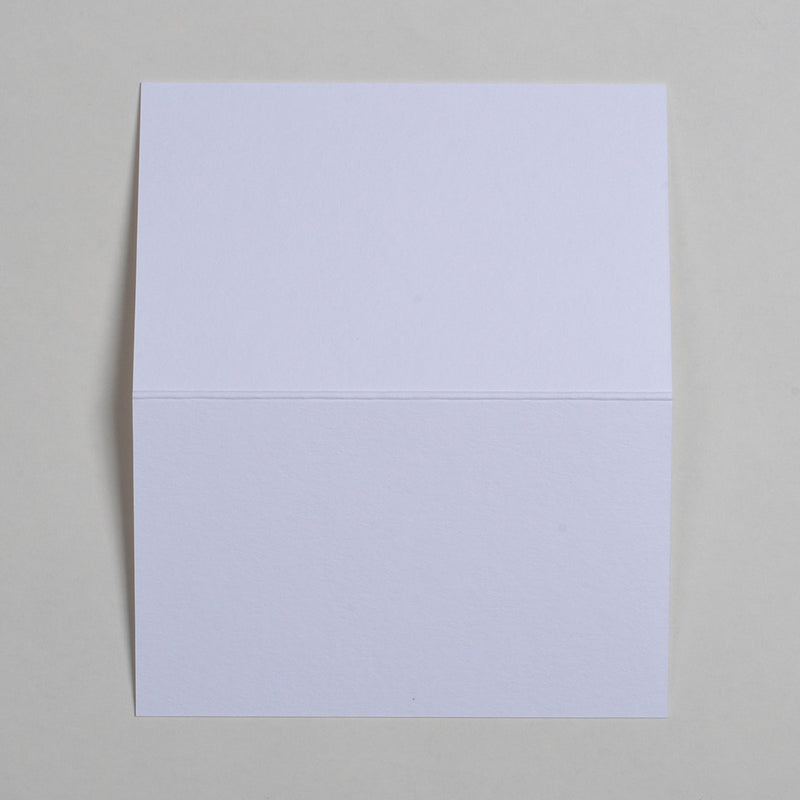 The Ivory Wedding name place cards shown flat on a table surface with the crease in the middle