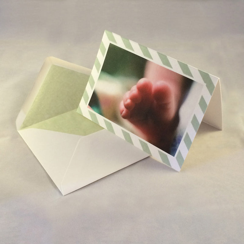 The lucy baby photo thank you cards, showing pastel green striped borders which complement the tone in the picture