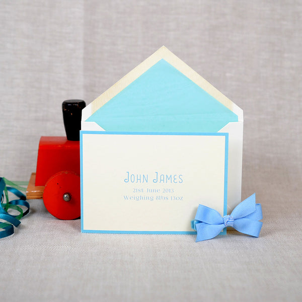 The Mountjoy birth announcement cards and envelope with baby blue tissue paper lining 