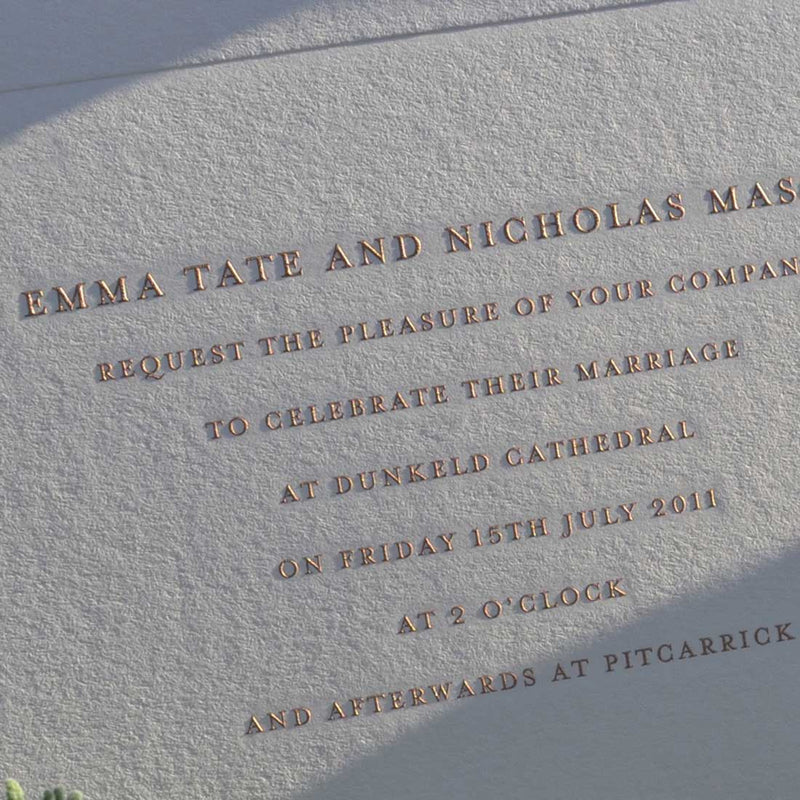 a close up of the glinting rose gold text on blush pink card of the Hampton engraved wedding invitation