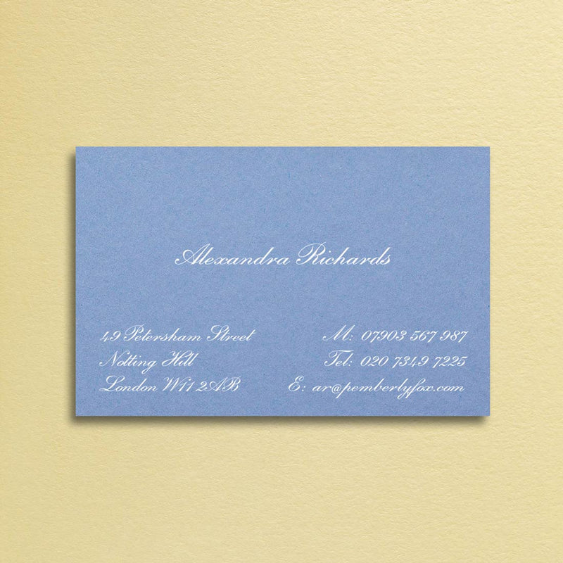 A classic script font printed in white ink onto a new blue visiting card