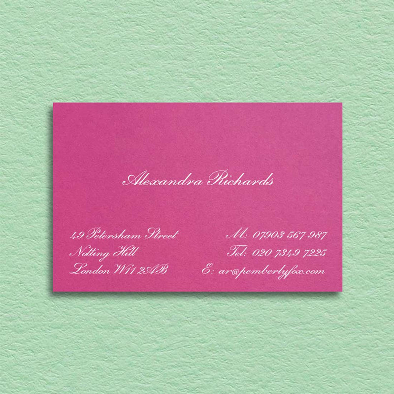 A classic script font printed in white ink onto a fuchsia pink visiting card