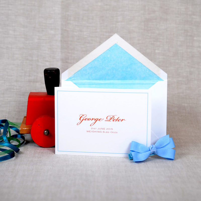 The folded Torville birth announcement cards and envelope with baby blue tissue paper lining