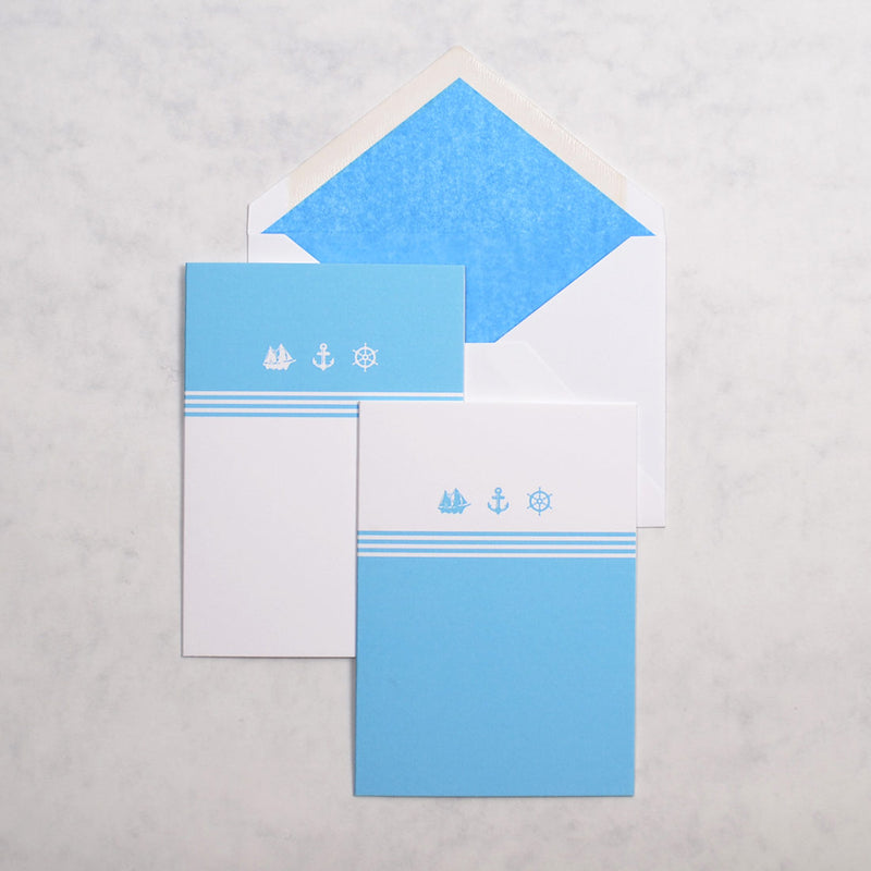 the light blue and white Antibes nautical greeting cards show 3 nautical motifs on portrait cards, with matching blue tissue paper lined white envelopes