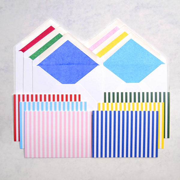 the beach hut pattern greeting cards, with vertical stripes, shown with matching tissue paper lined white envelopes