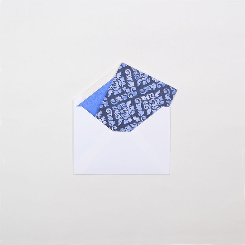 the blue damask pattern greeting card shown in it's white envelope which are lined in dark blue tissue paper
