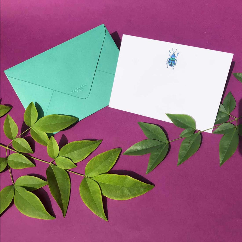 The green bug note card shows a single motif sketch at the head and comes with forest green envelopes 