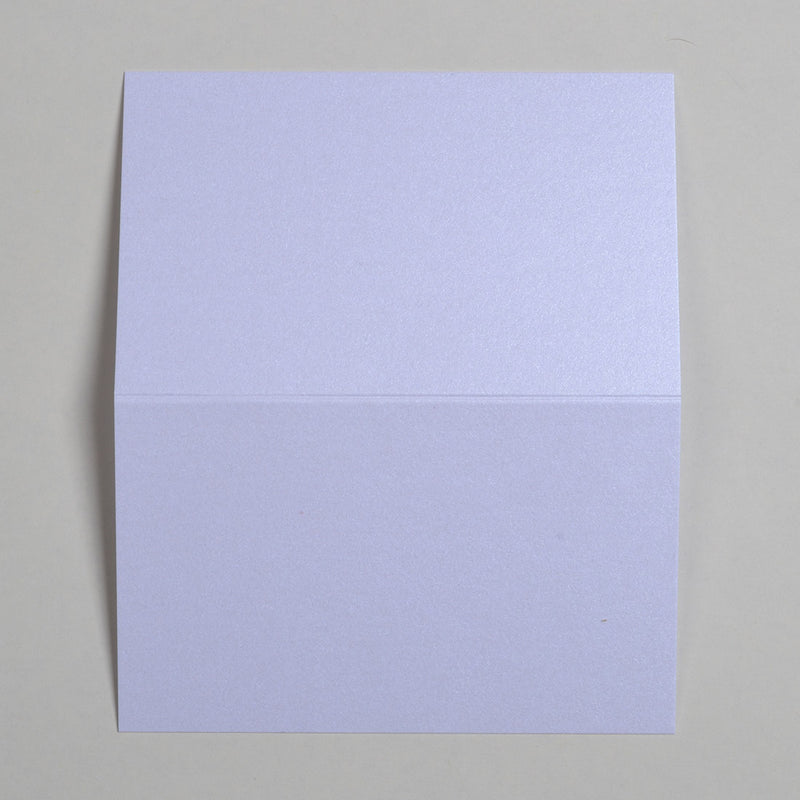 The Marble White Wedding name place cards shown flat on a table surface with the crease in the middle