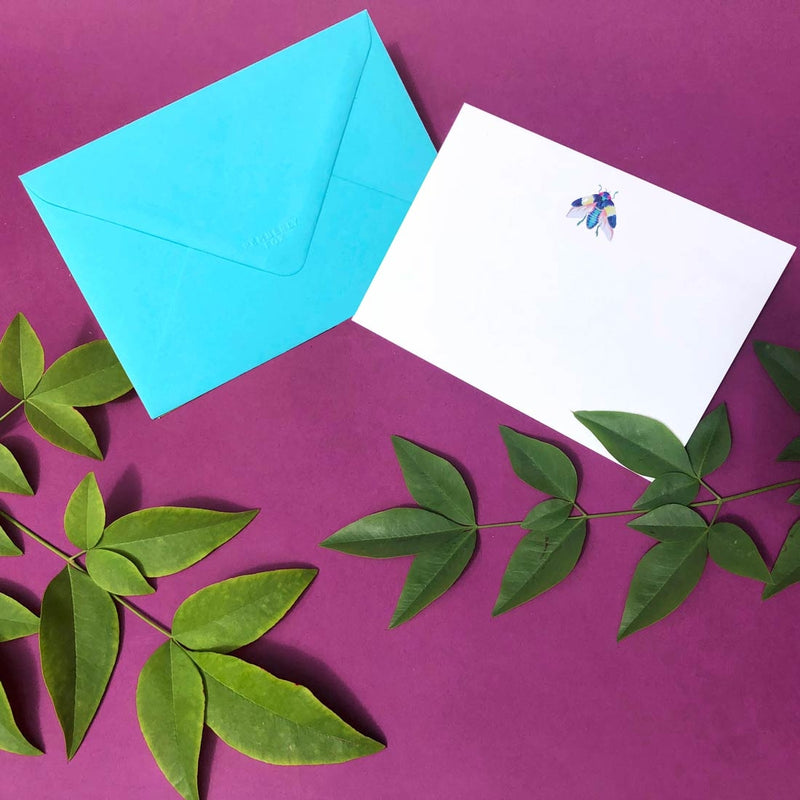 The open bug note card shows a single motif sketch at the head and comes with turquoise envelopes 