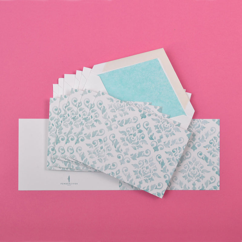 the teal damask pattern greeting cards shown fanned out with matching tissue paper lined envelopes